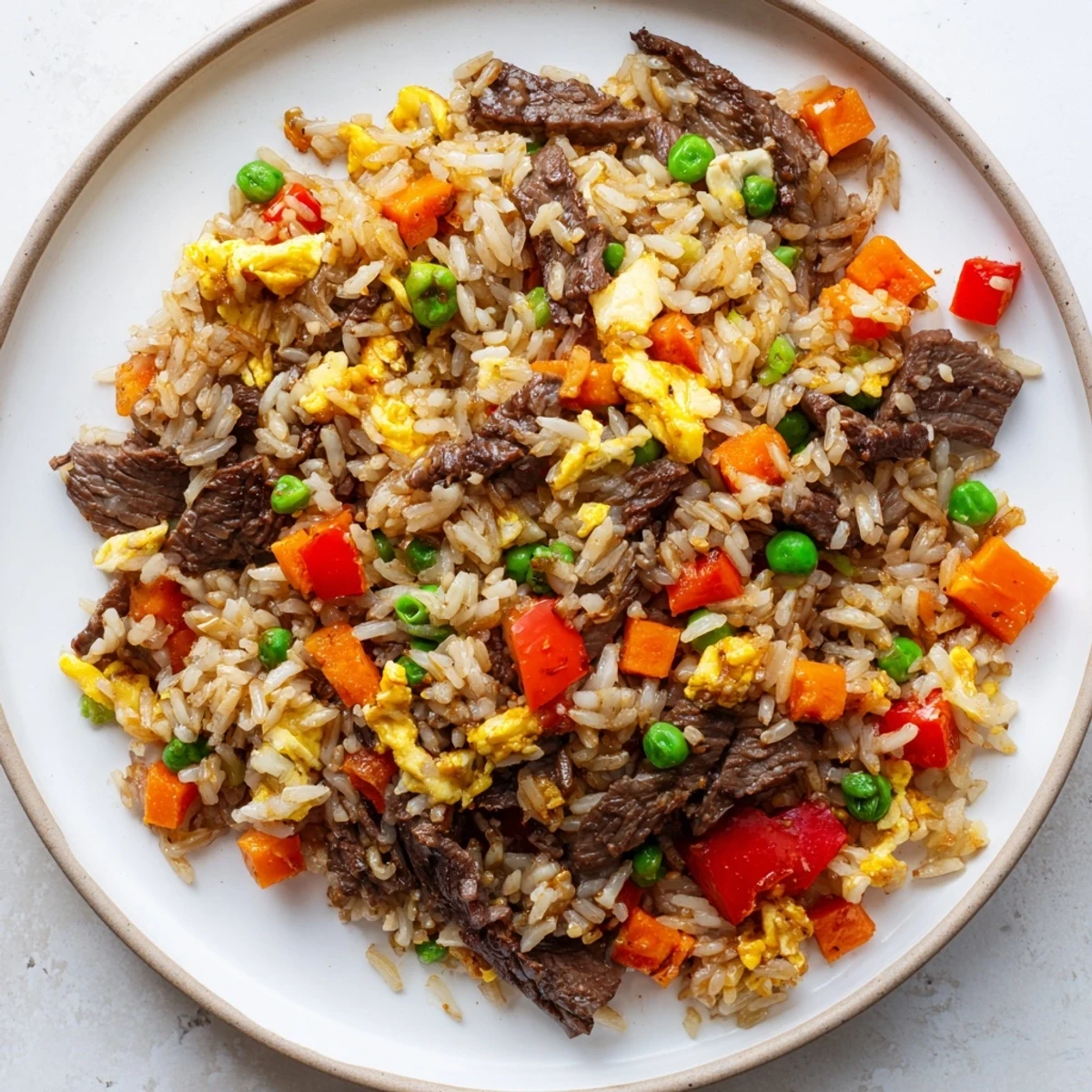 Fork-tender beef and colorful vegetables mix with fluffy rice in this savory Beef Fried Rice with Vegetables.