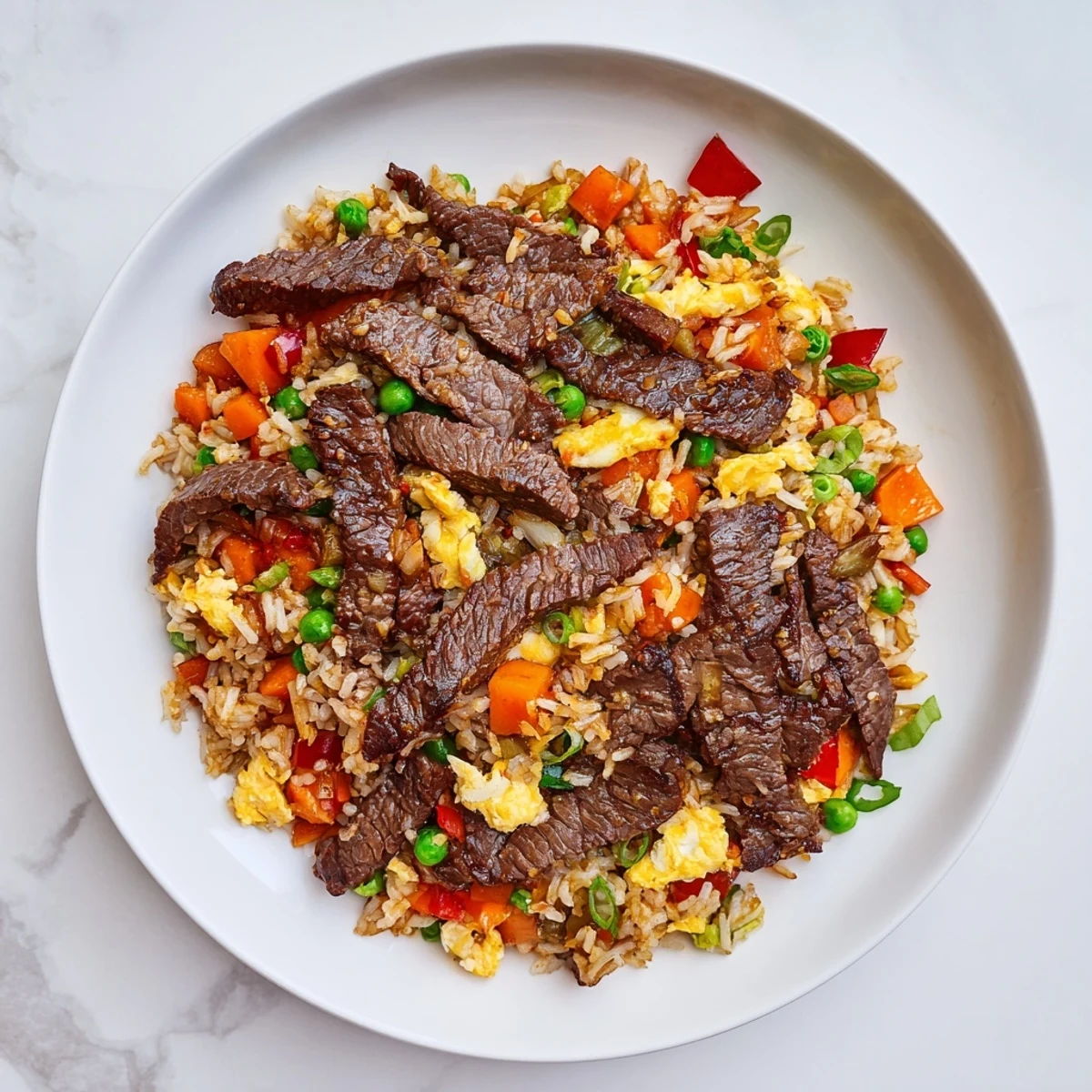 A steaming wok of Beef Fried Rice with Vegetables, garnished with scallions, ready for a quick weeknight dinner.