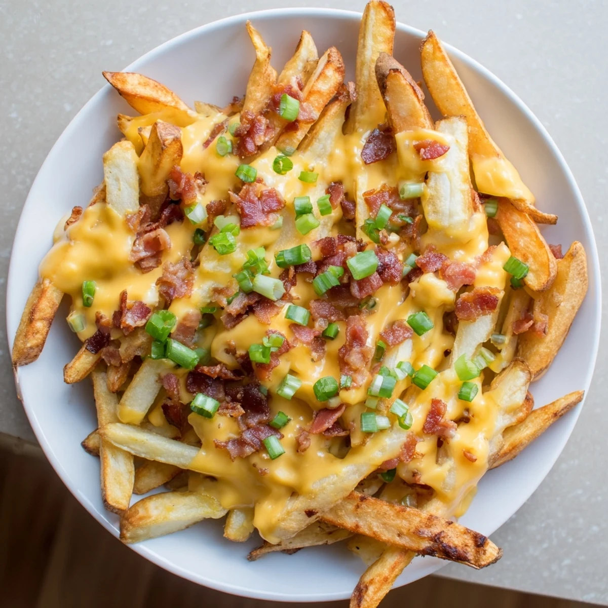 Crispy russet potato fries loaded with cheddar and savory turkey bacon for snacking.