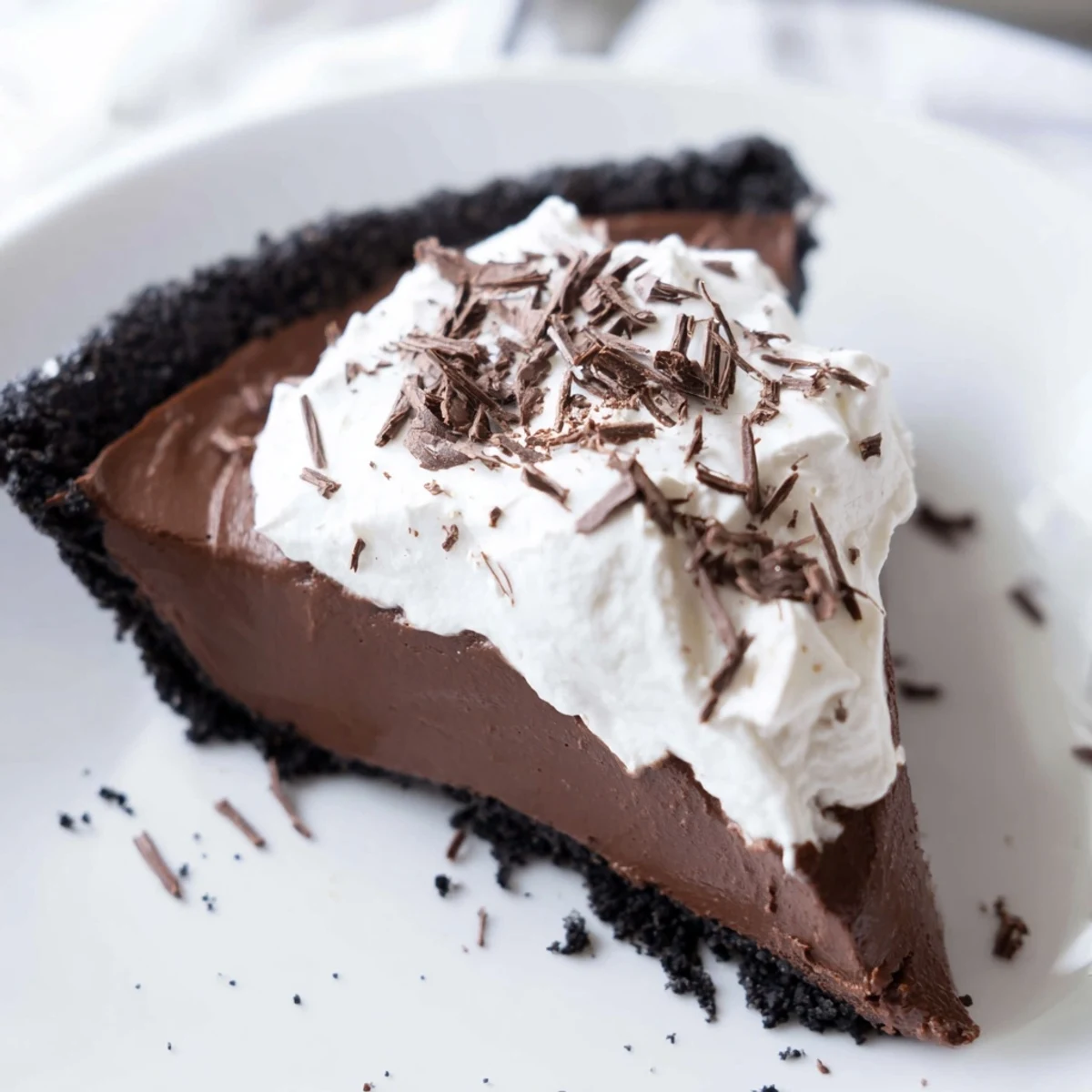 Freshly whipped cream and chocolate shavings top this decadent chocolate silk pie, perfect for holiday dessert tables.