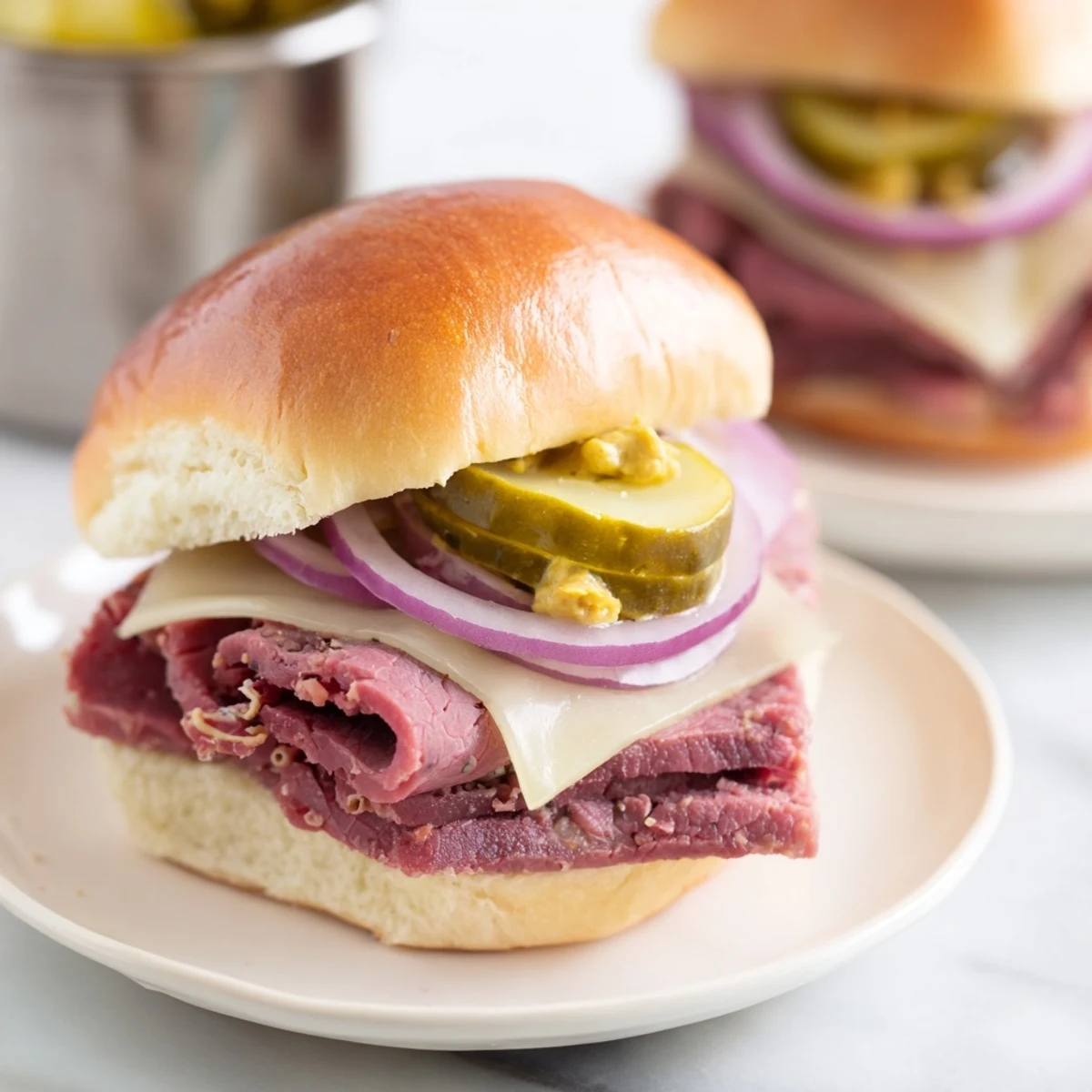 Golden-brown Corned Beef Sliders with mustard glaze, melted Swiss cheese, and dill pickles on soft slider buns.