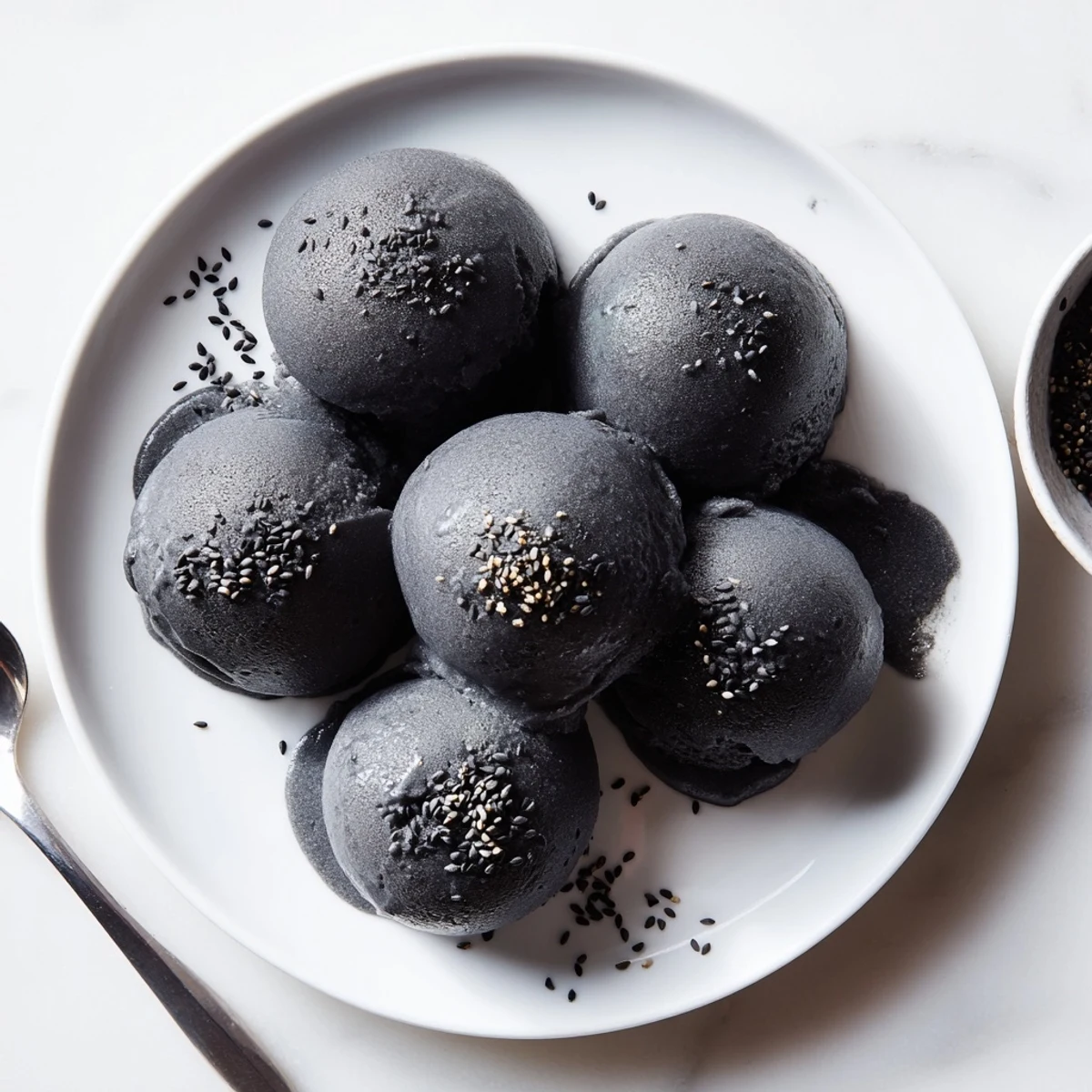 A freshly churned batch of Toasted Black Sesame Ice Cream shows a rich, dense swirl, perfect for serving after an Asian-inspired dinner.