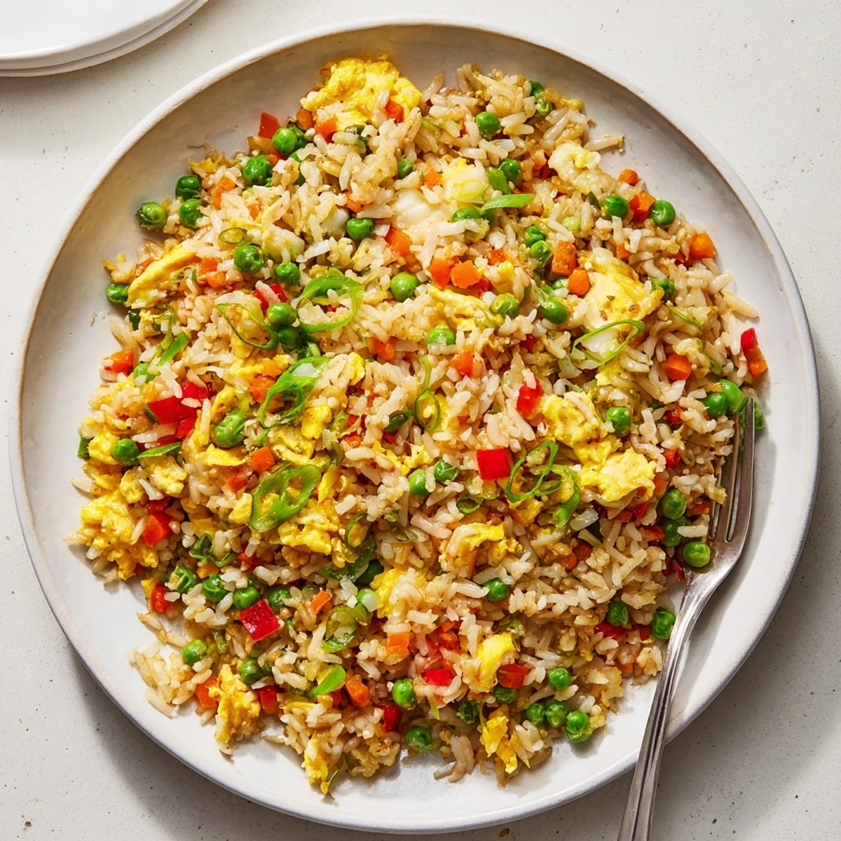 Steaming hot Fried Rice in a skillet with scrambled eggs, green onions, and savory soy sauce, ready to serve.  