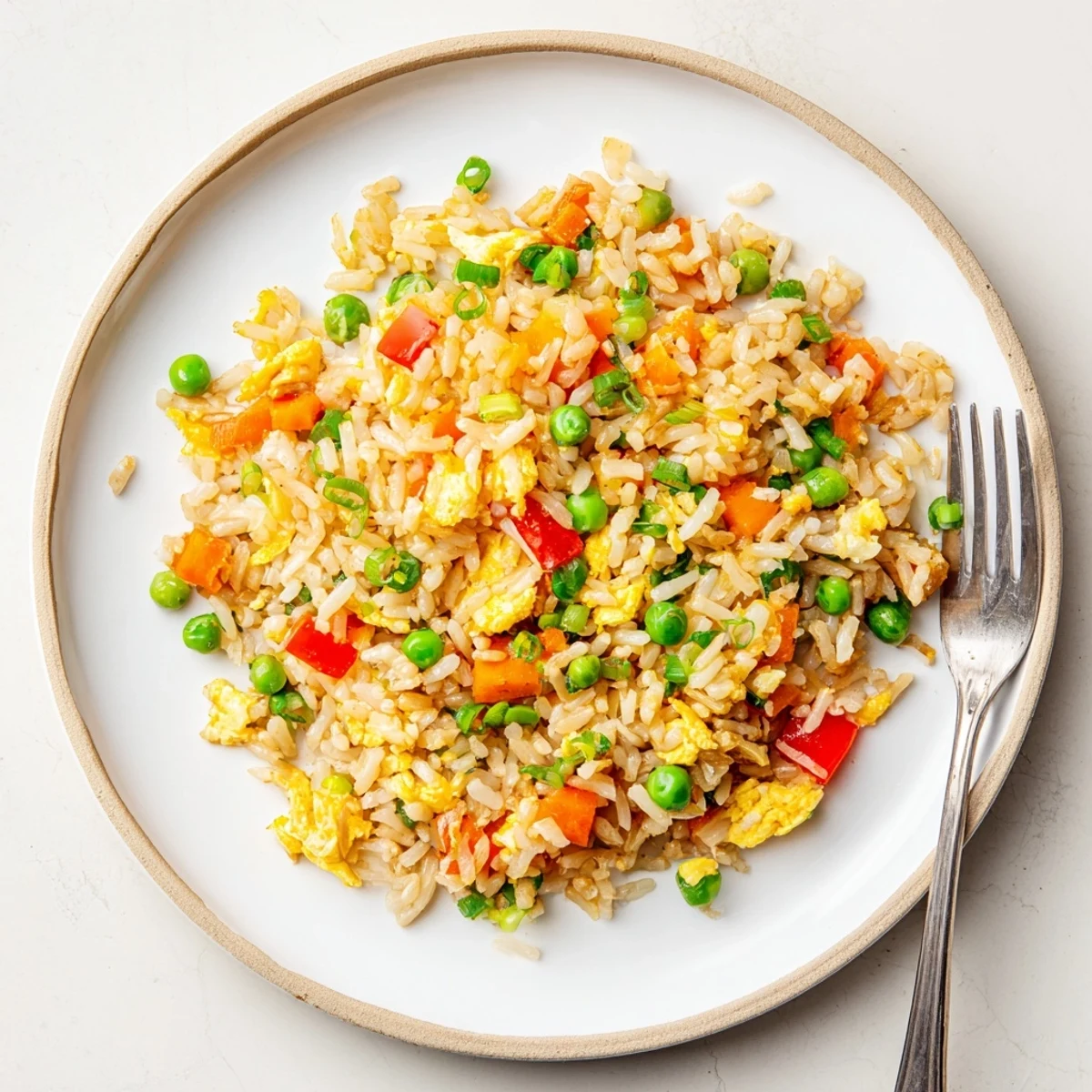 A vibrant bowl of vegetarian Fried Rice featuring tender vegetables and jasmine rice, garnished with fresh green onions.