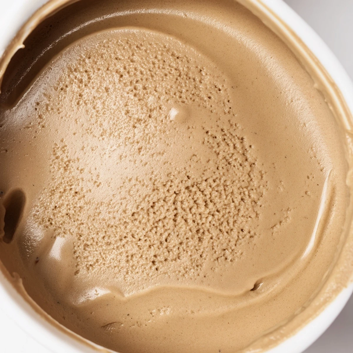 Rich Hojicha Ice Cream in a dessert glass garnished with a delicate tea leaf, perfect for a unique Japanese-inspired treat.