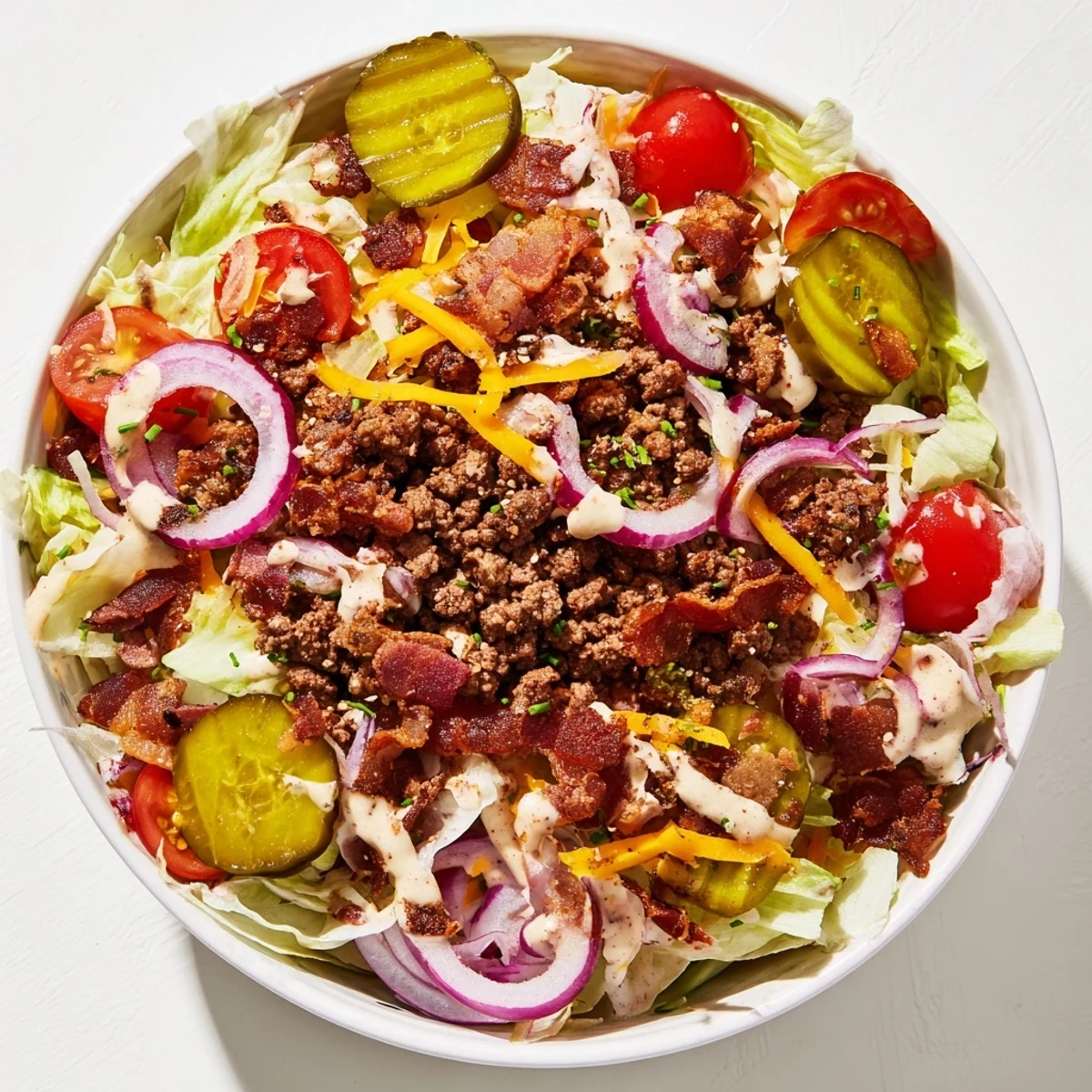 Crushed burger patty, cheddar, and pickles in a Smash Burger Bowl with smoky sauce.