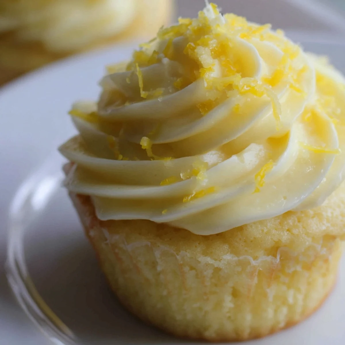 Ready-to-serve Limoncello Cupcakes on a white plate, perfect for summer gatherings or a refreshing Italian dessert.