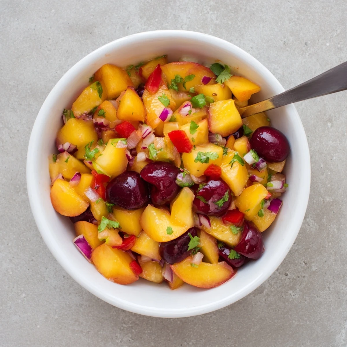 A bowl of Healthy Peach Cherry Salsa with diced peaches, cherries, and cilantro, served with tortilla chips.