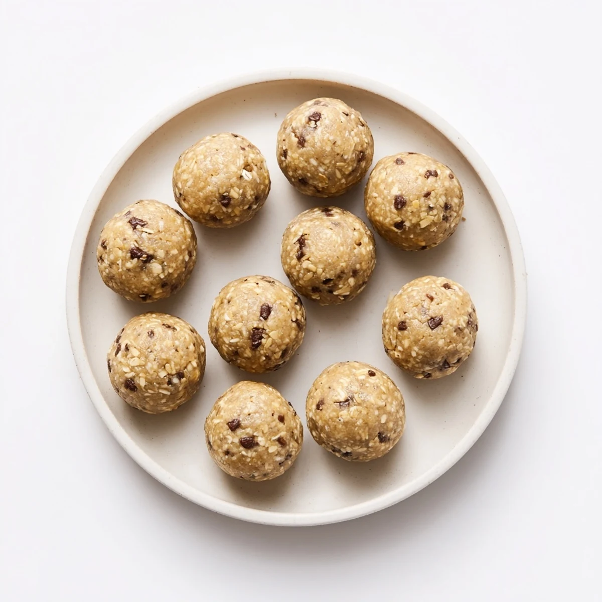 Close-up of mint chocolate chip protein balls on a rustic wooden board with fresh mint garnish.