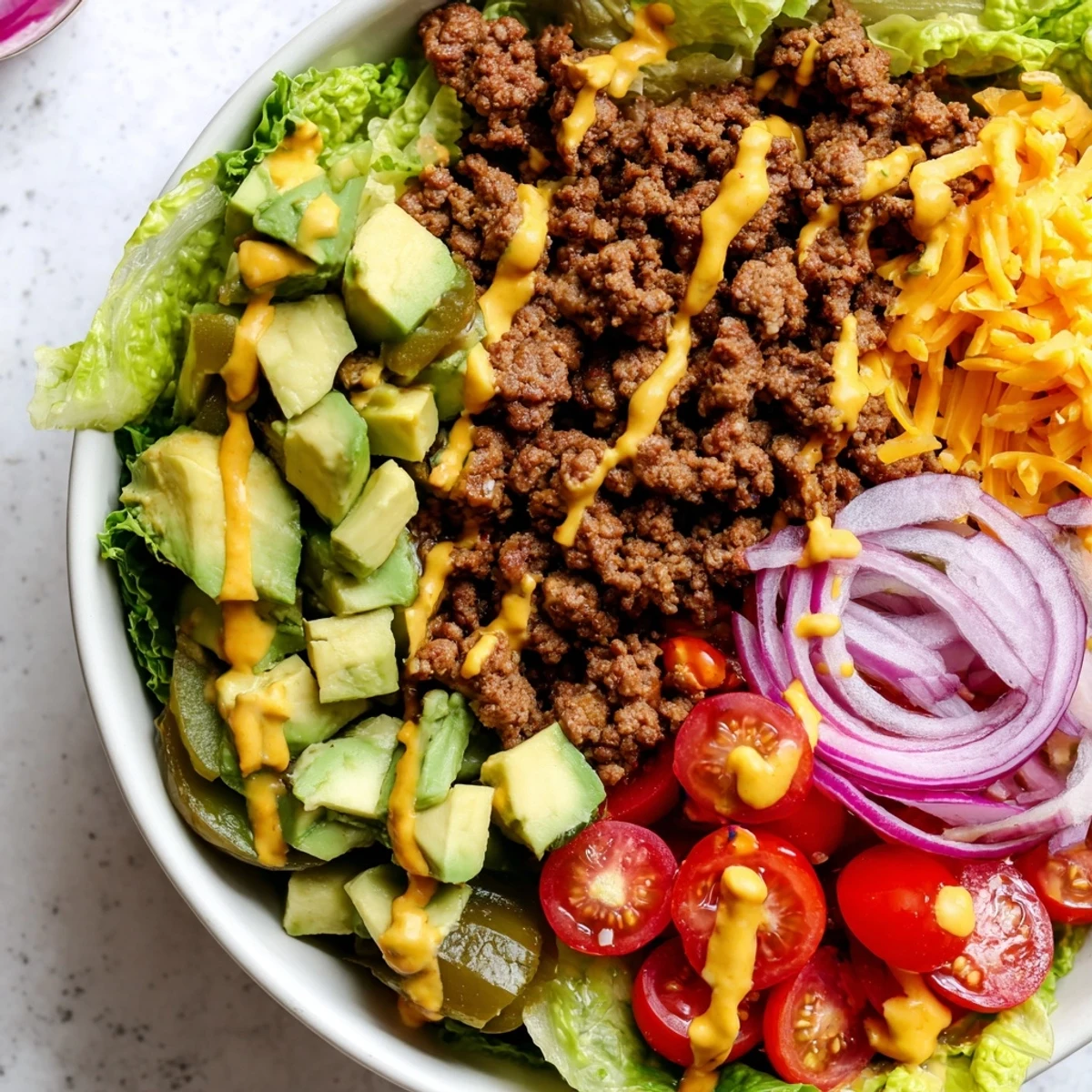 Burger bowls with seasoned ground beef, fresh vegetables, cheddar cheese, and creamy special sauce