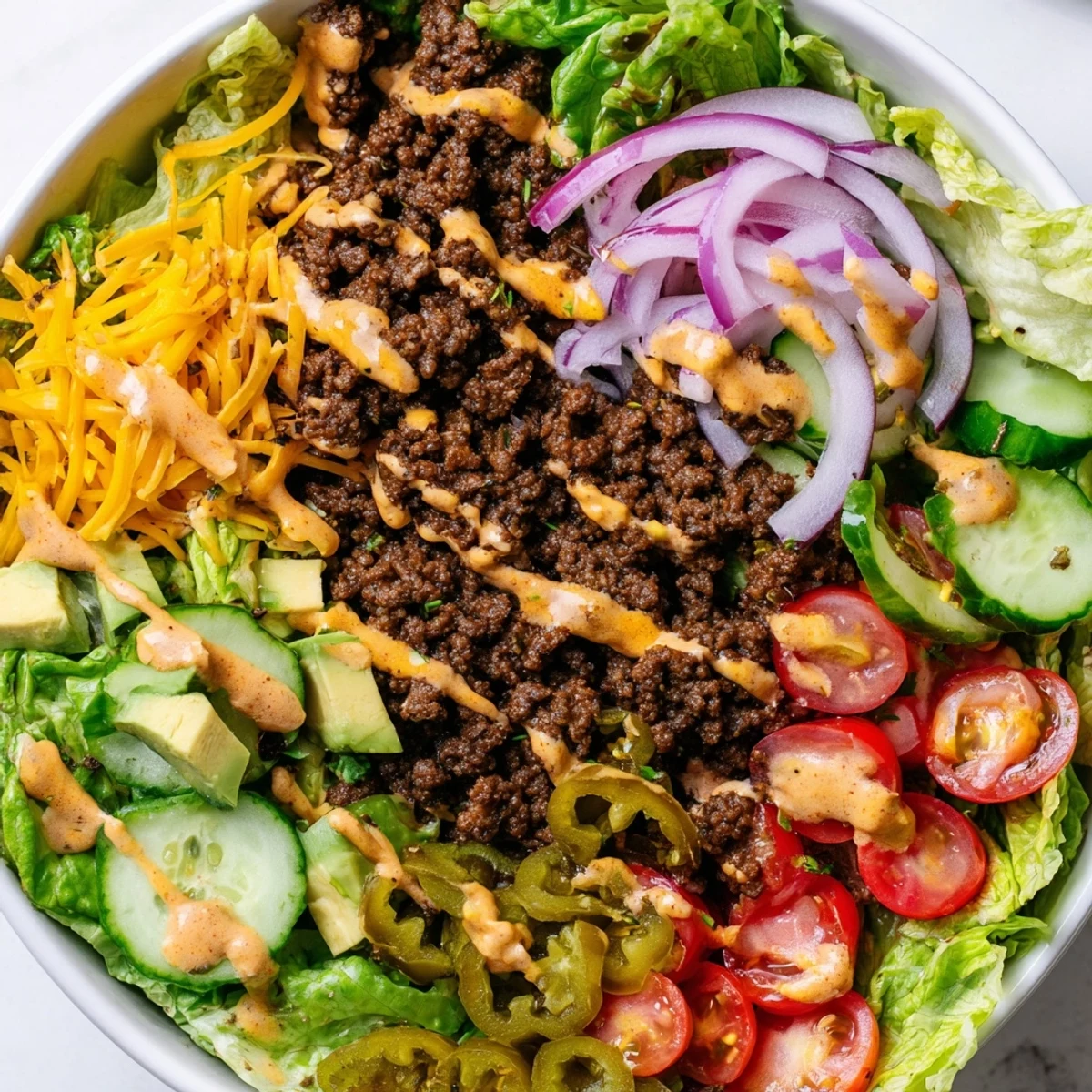 Low-carb burger bowls featuring juicy beef, crisp lettuce, tomatoes, pickles, and tangy dressing