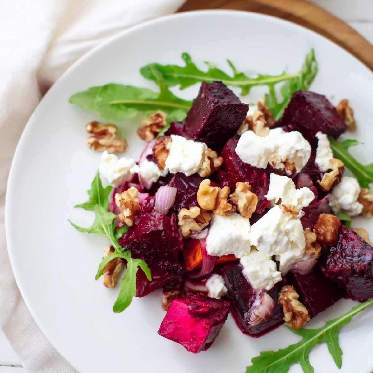 Vibrant bowl of roasted beet and sweet potato salad with feta crumbles, toasted nuts, and honey yogurt dressing