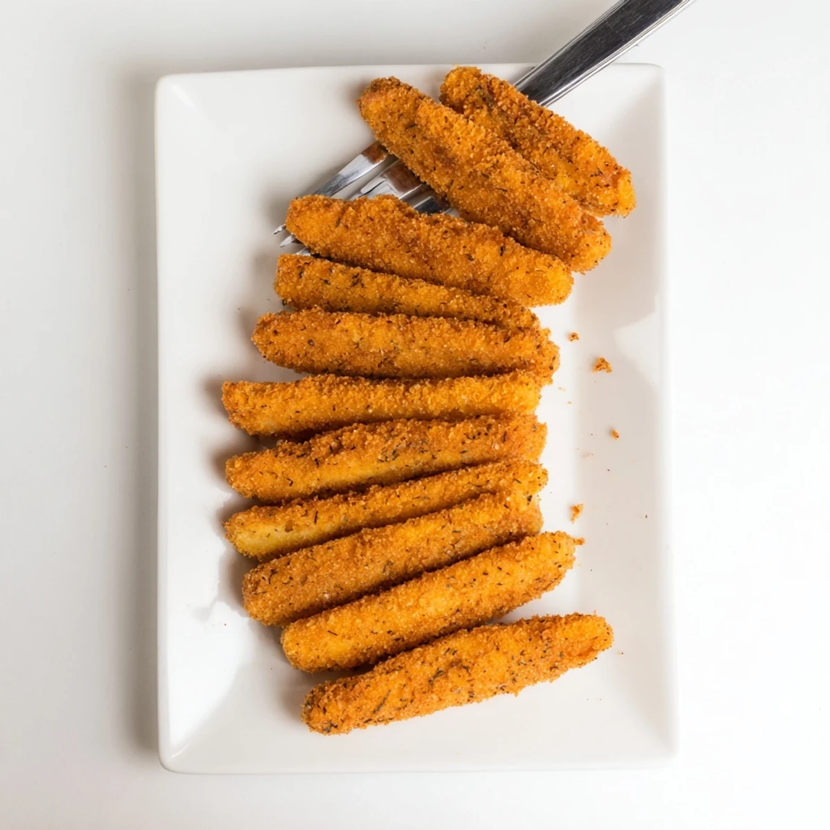 Golden-brown fried ham and cheese sticks arranged on a white serving platter with marinara dipping sauce