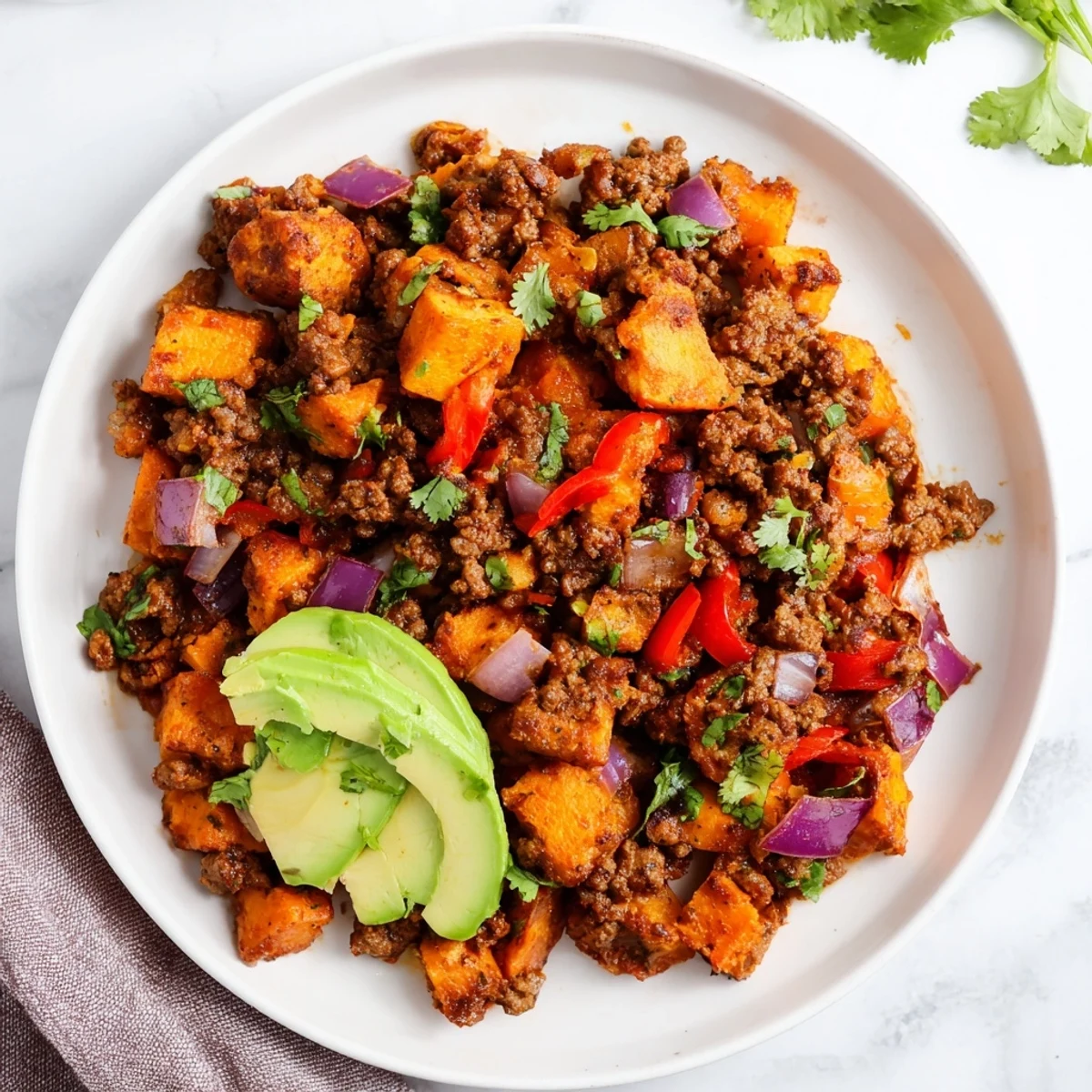 Hearty one-pan Southwest ground beef and sweet potato skillet featuring colorful red bell peppers and onions