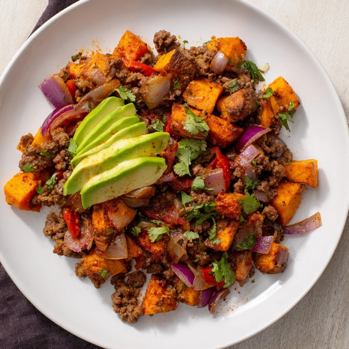 Savory Southwest ground beef and sweet potato skillet served hot with melted cheddar cheese and fresh cilantro