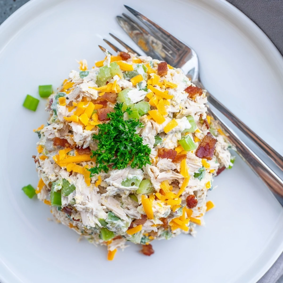 Golden bowl of low carb jalapeno popper cottage cheese chicken salad served on crisp green lettuce leaves