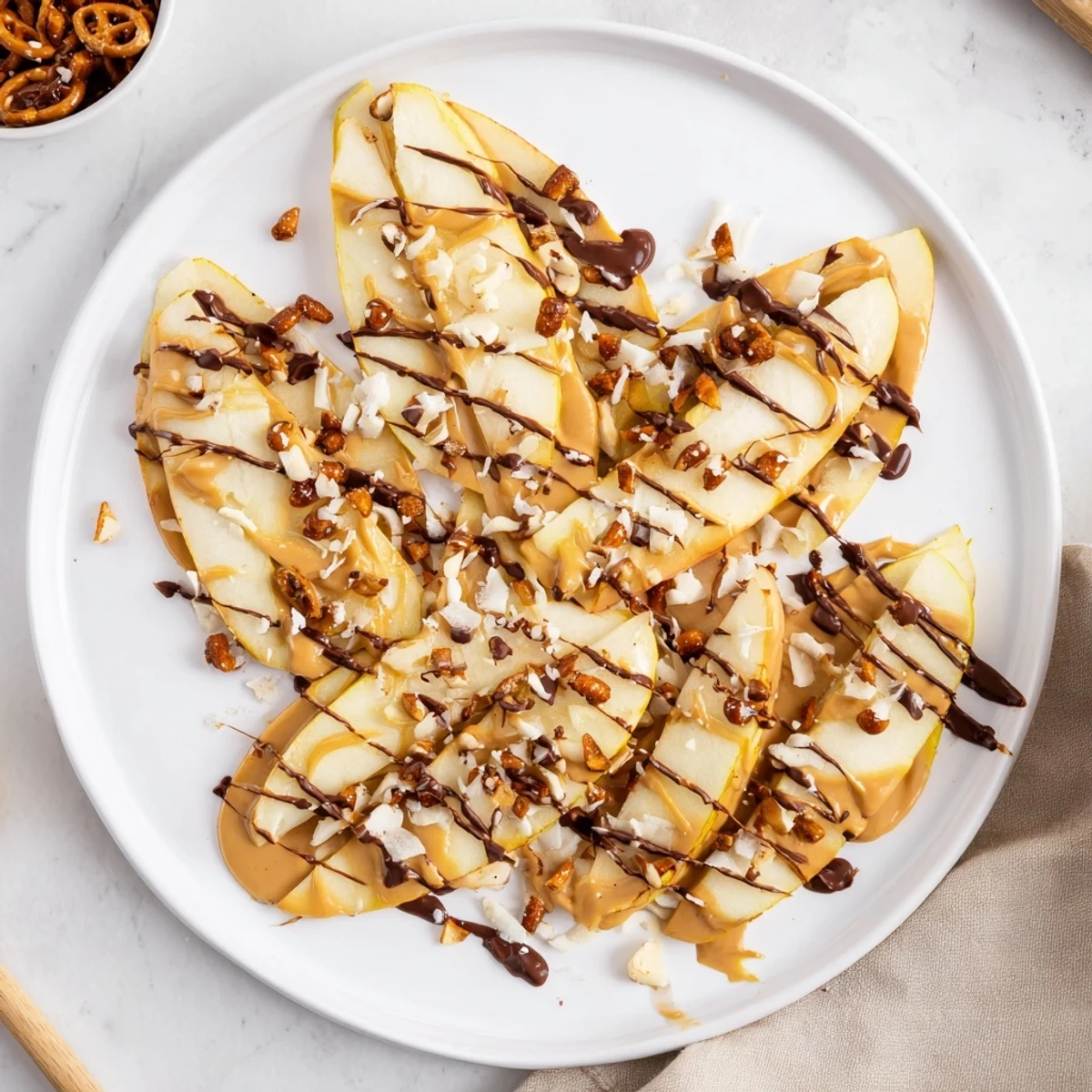 Fresh apple slices arranged on a platter topped with peanut butter and chocolate nachos