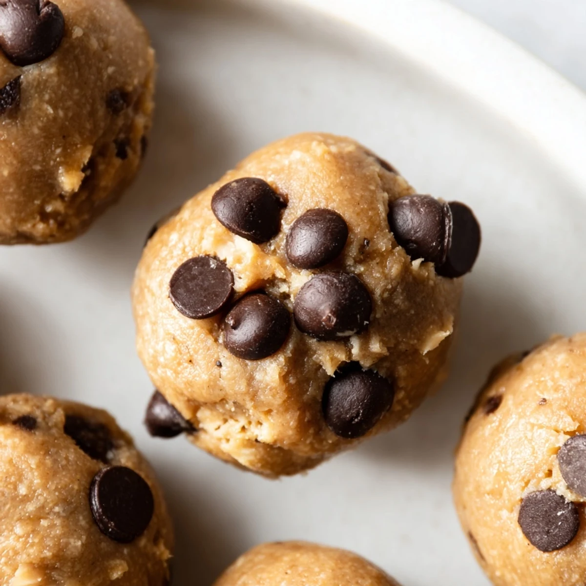 Bite-sized chocolate chip cookie dough protein balls rolled and ready for healthy snacking