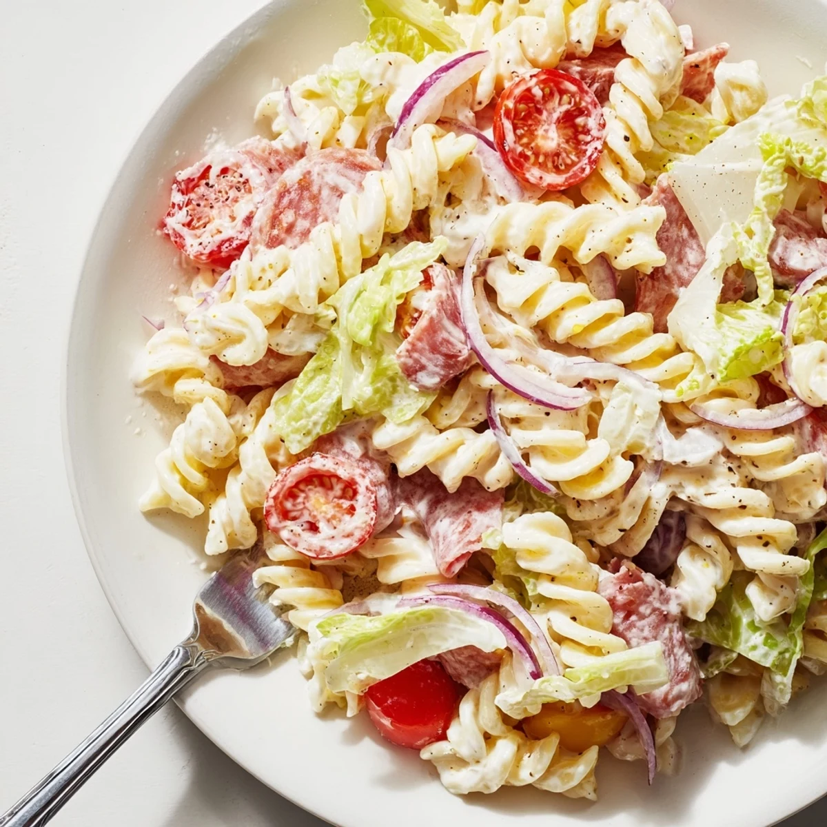Hearty grinder pasta salad tossed with creamy dressing and roasted red peppers