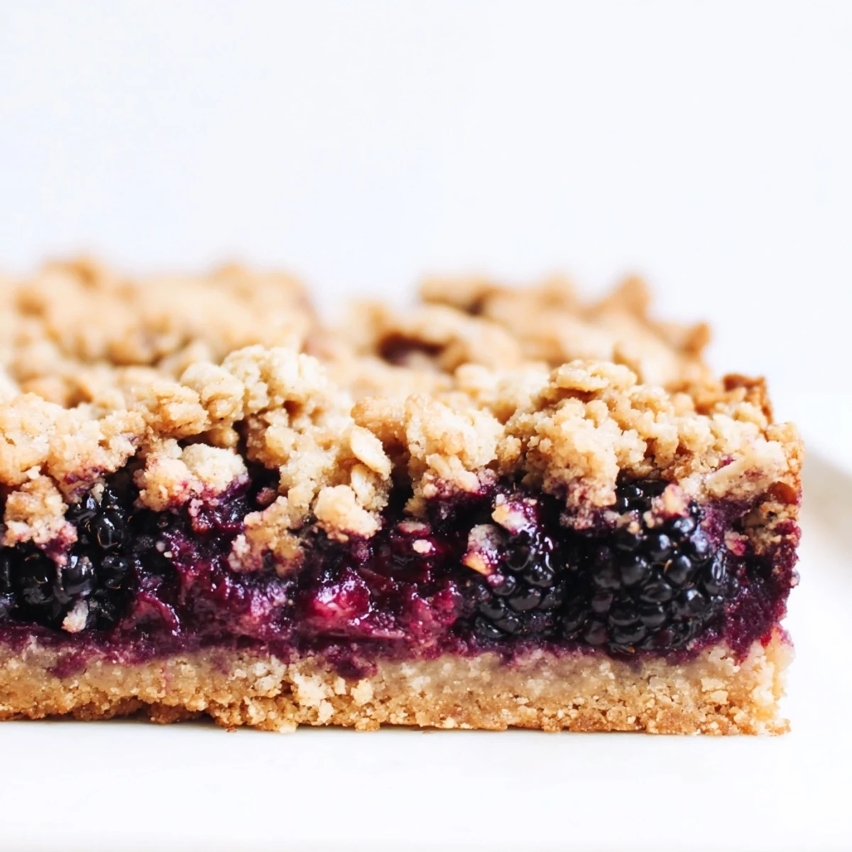Golden homemade blackberry crumble bars with bubbling fruit filling and buttery oat crumb topping