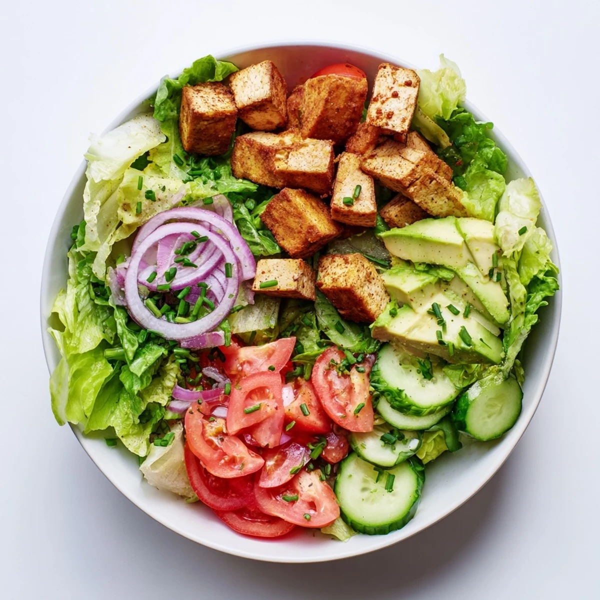 Golden smoky tofu cubes atop crisp romaine lettuce with juicy ripe tomatoes