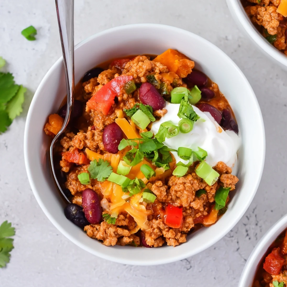 Hearty bowl of turkey pumpkin chili garnished with fresh cilantro and cheese