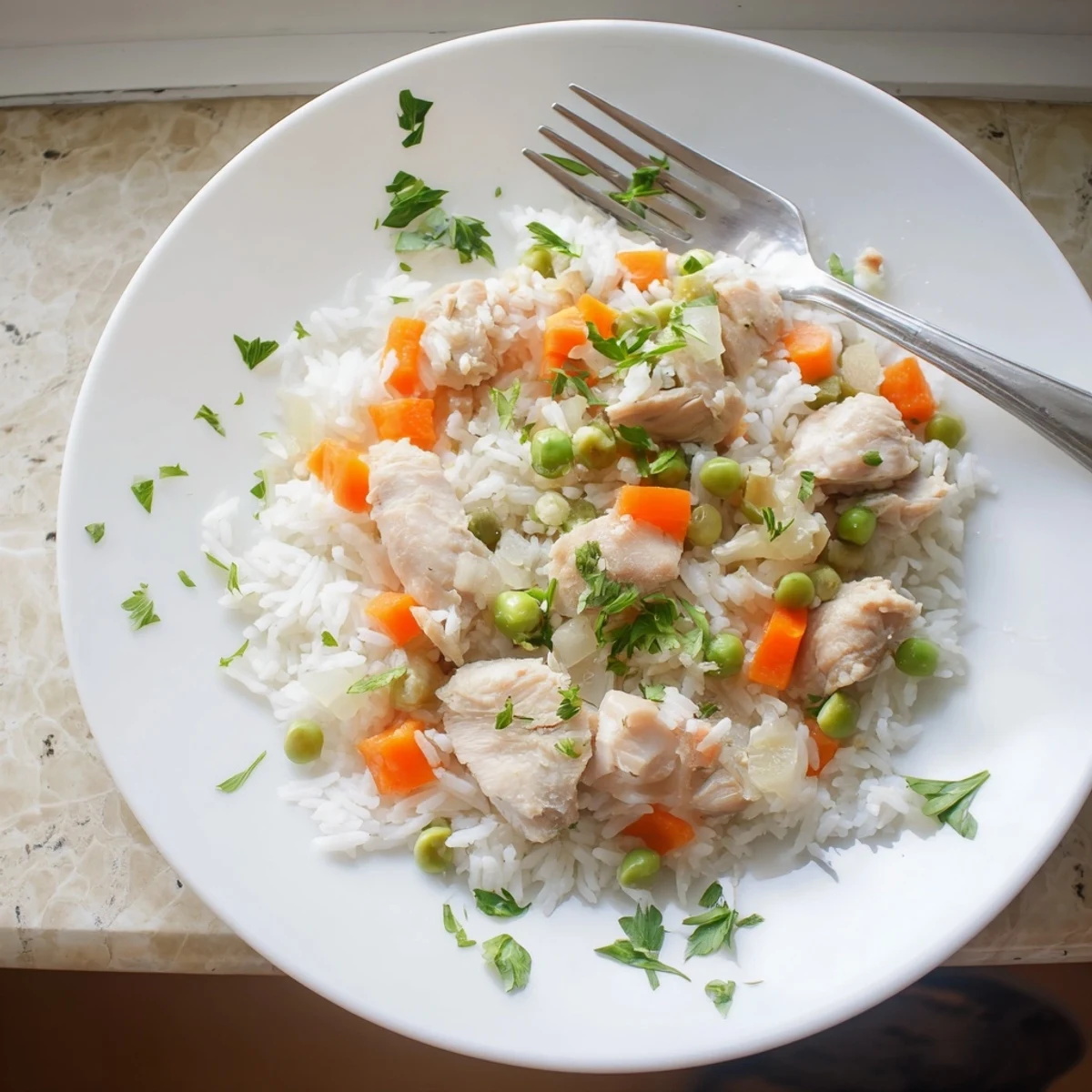 Comforting Instant Pot chicken and rice recipe plated with tender meat carrots and green peas
