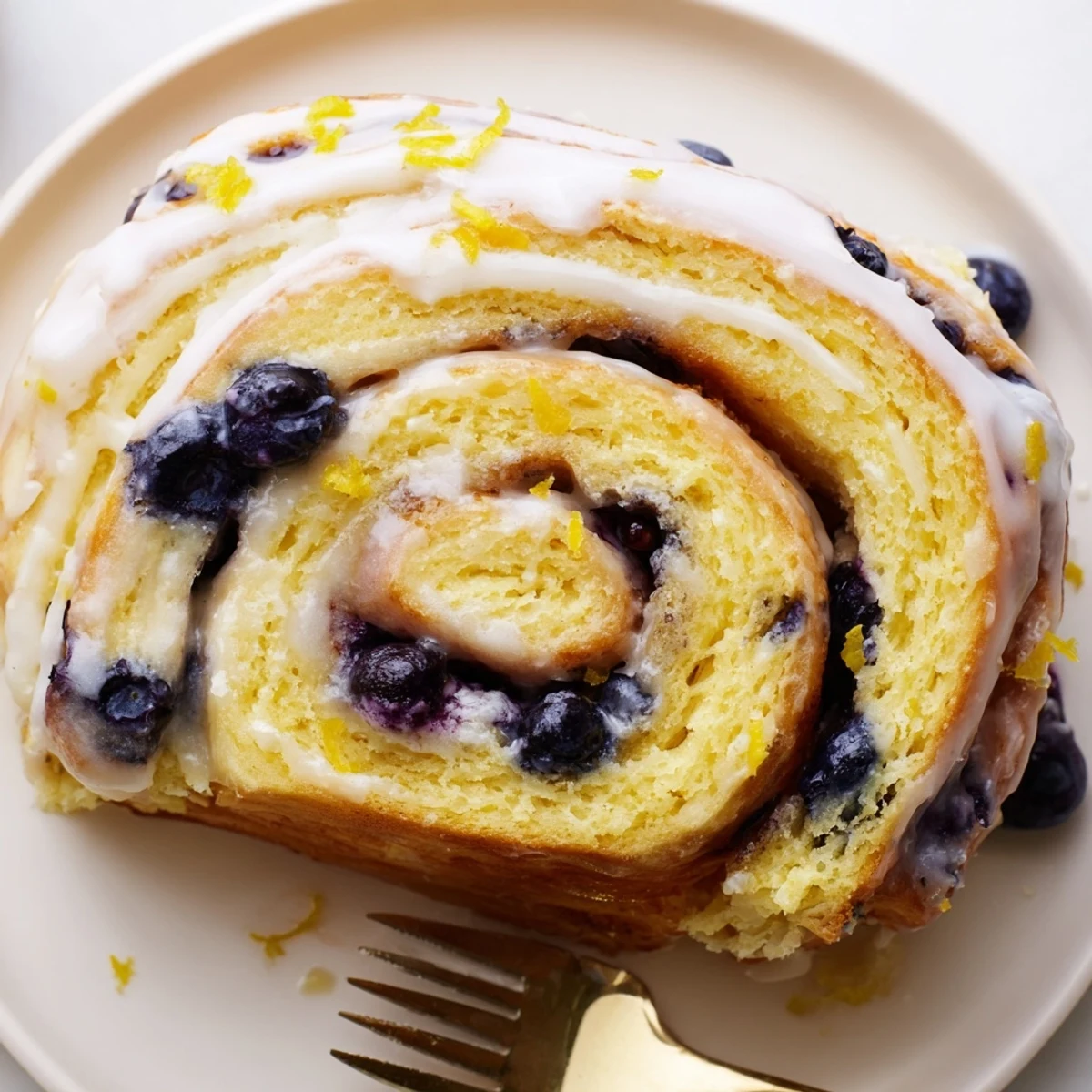 Freshly baked lemon blueberry rolls with purple blueberry swirls and white lemon icing