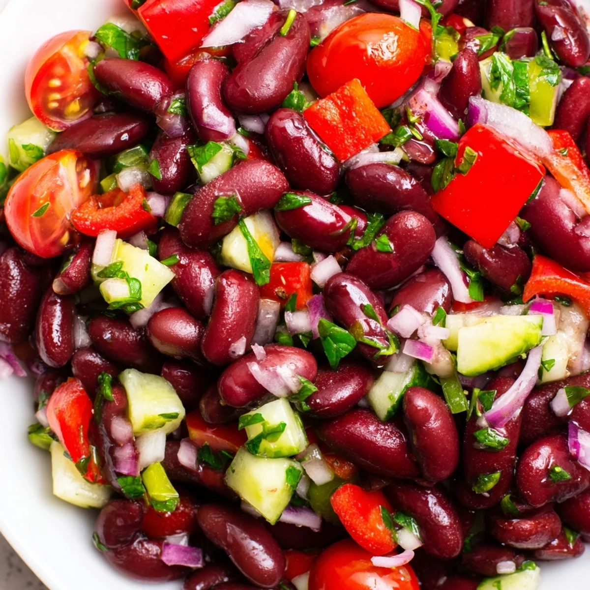 Kidney bean salad tossed with diced cucumbers and tangy vinaigrette in clear serving dish