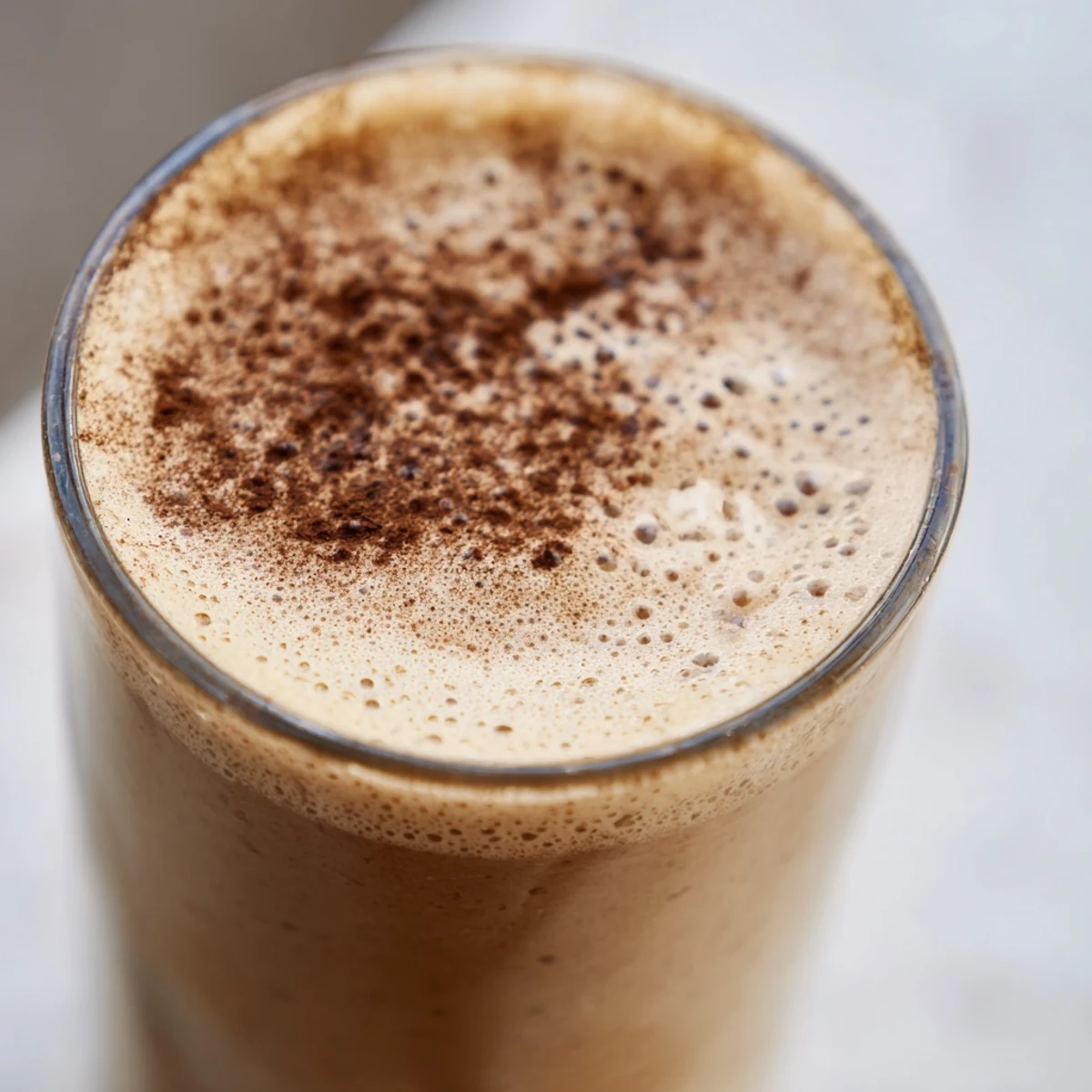 Frothy coffee smoothie blended with ripe banana and served ice cold