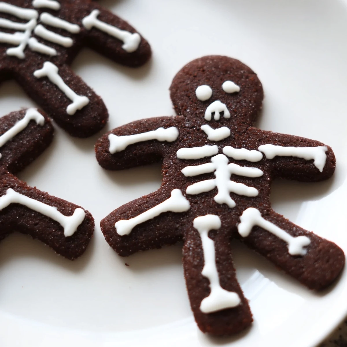 Chocolate Cinnamon Skeleton Cookies with white icing bones on a parchment-lined baking sheet