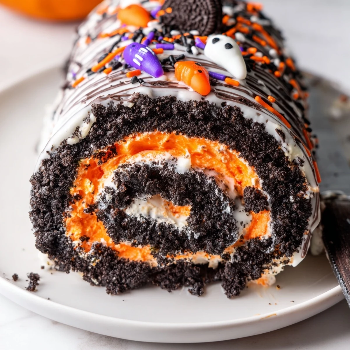 Halloween Oreo Roll chilled log topped with chocolate drizzle and colorful Halloween sprinkles ready to serve