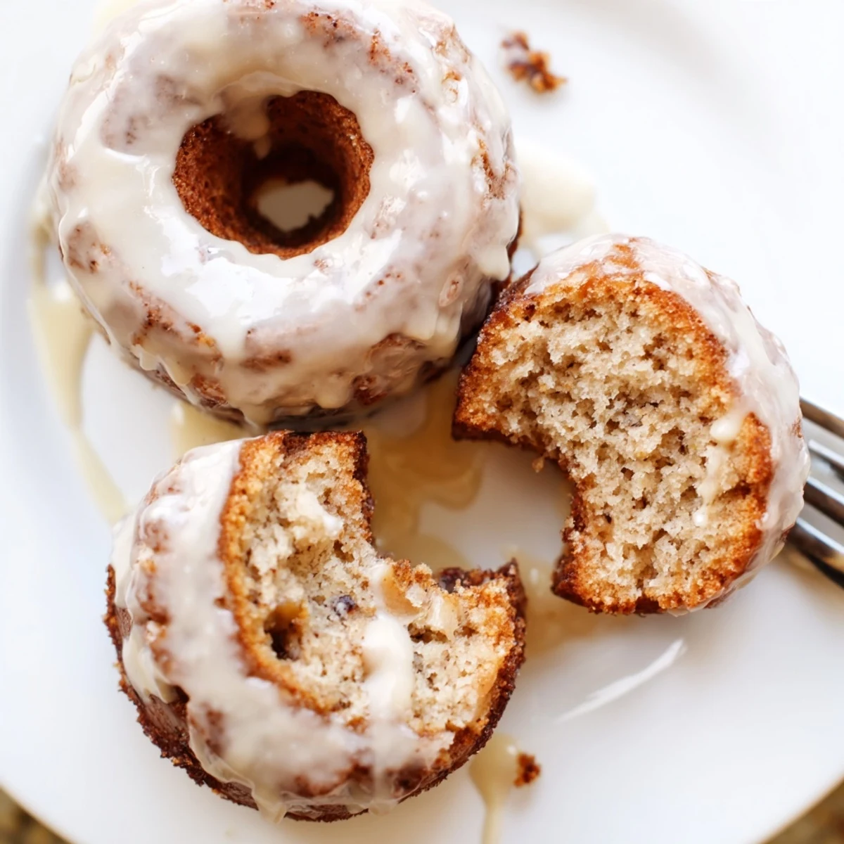 Glazed Banana Donuts piled on plate, soft crumb and cinnamon hint