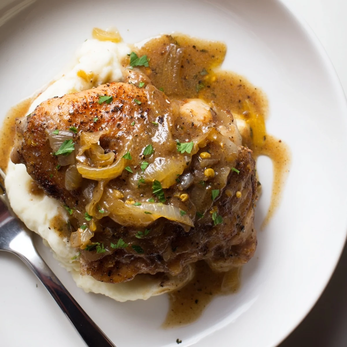 Golden-skinned Savory Smothered Chicken Thighs In Rich Gravy Recipe simmered until tender