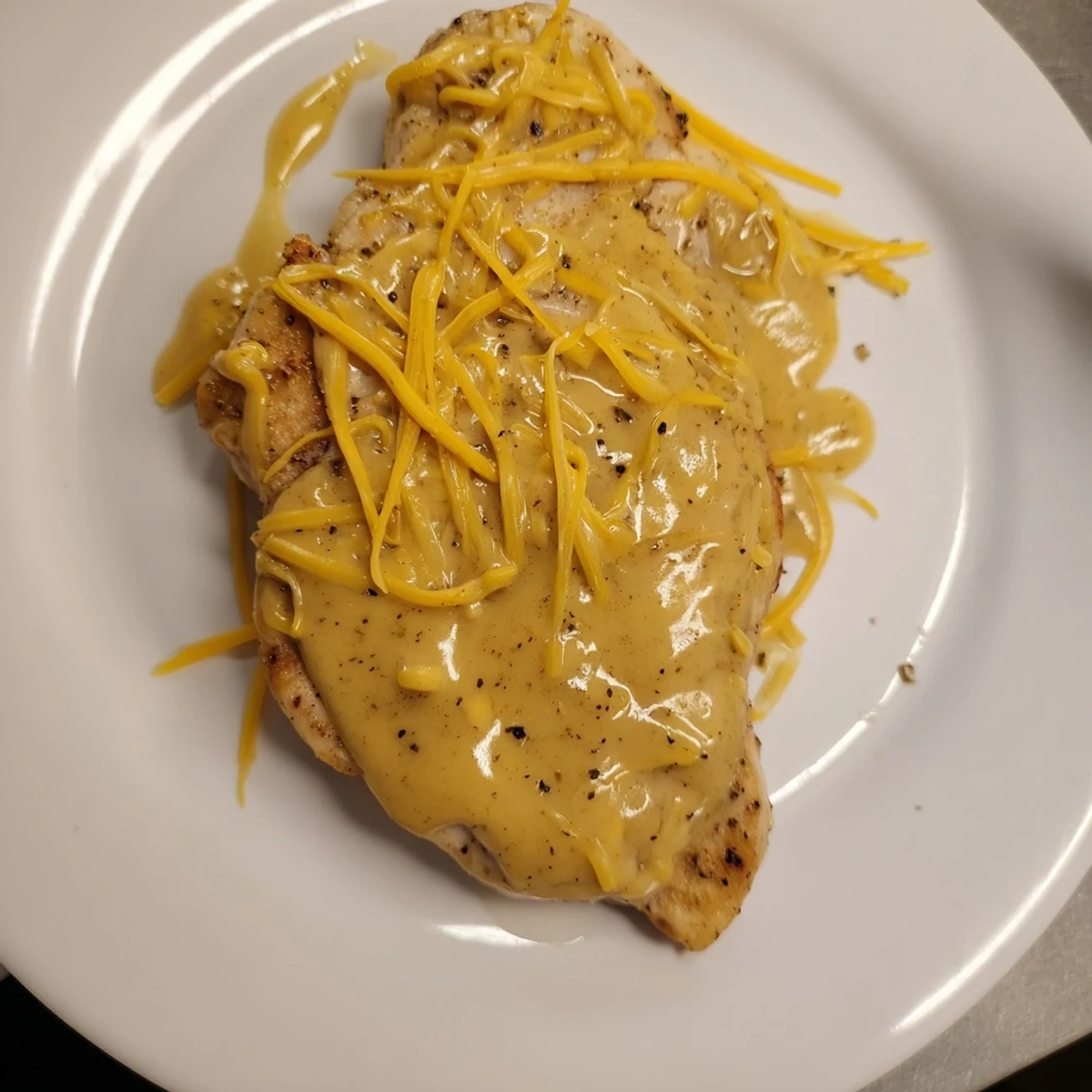 Oven baked Chicken With Cheese Sauce spooned hot over mashed potatoes, aromatic