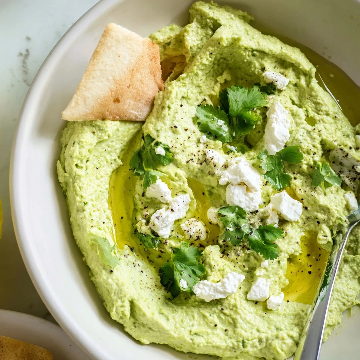 Party ready Creamy Avocado Feta Dip topped with crumbled feta and cilantro