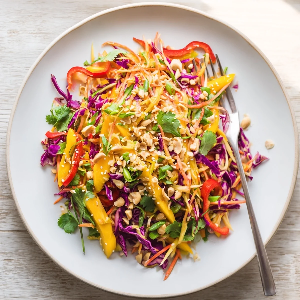 Golden refreshing mango slaw featuring crunchy red cabbage and sweet julienned mango pieces in a lime dressing