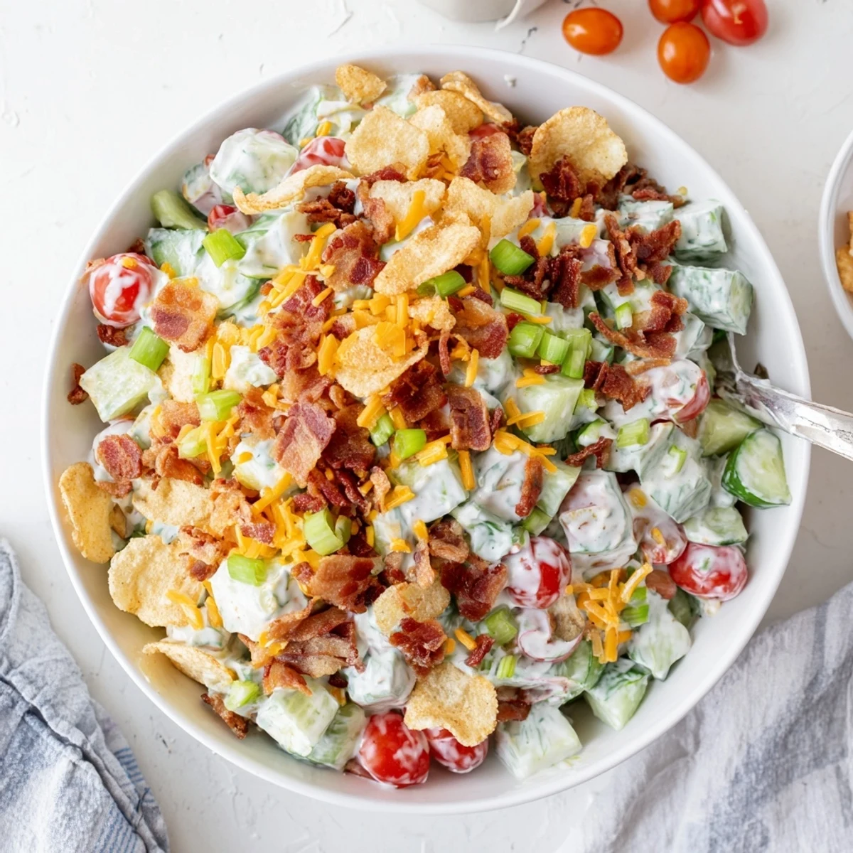 Colorful cucumber ranch crack salad featuring crisp vegetables, savory bacon crumbles, and cheddar cheese