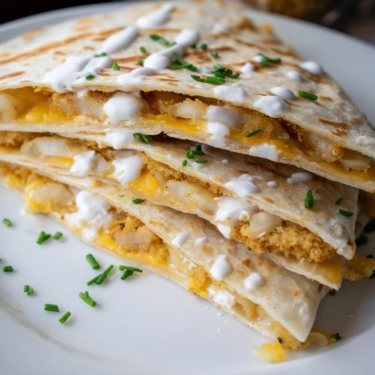 Sliced quesadilla revealing crunchy fried onion rings nestled between oozy layers of cheese