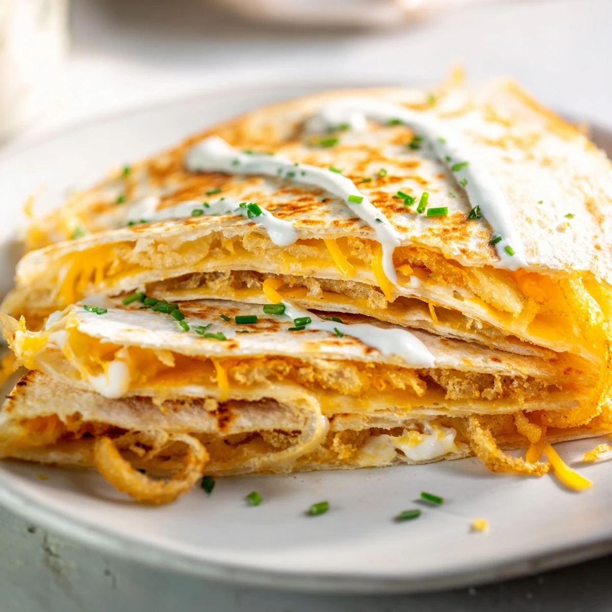 Tex-Mex appetizer featuring fried onion rings stuffed inside cheesy grilled flour tortillas