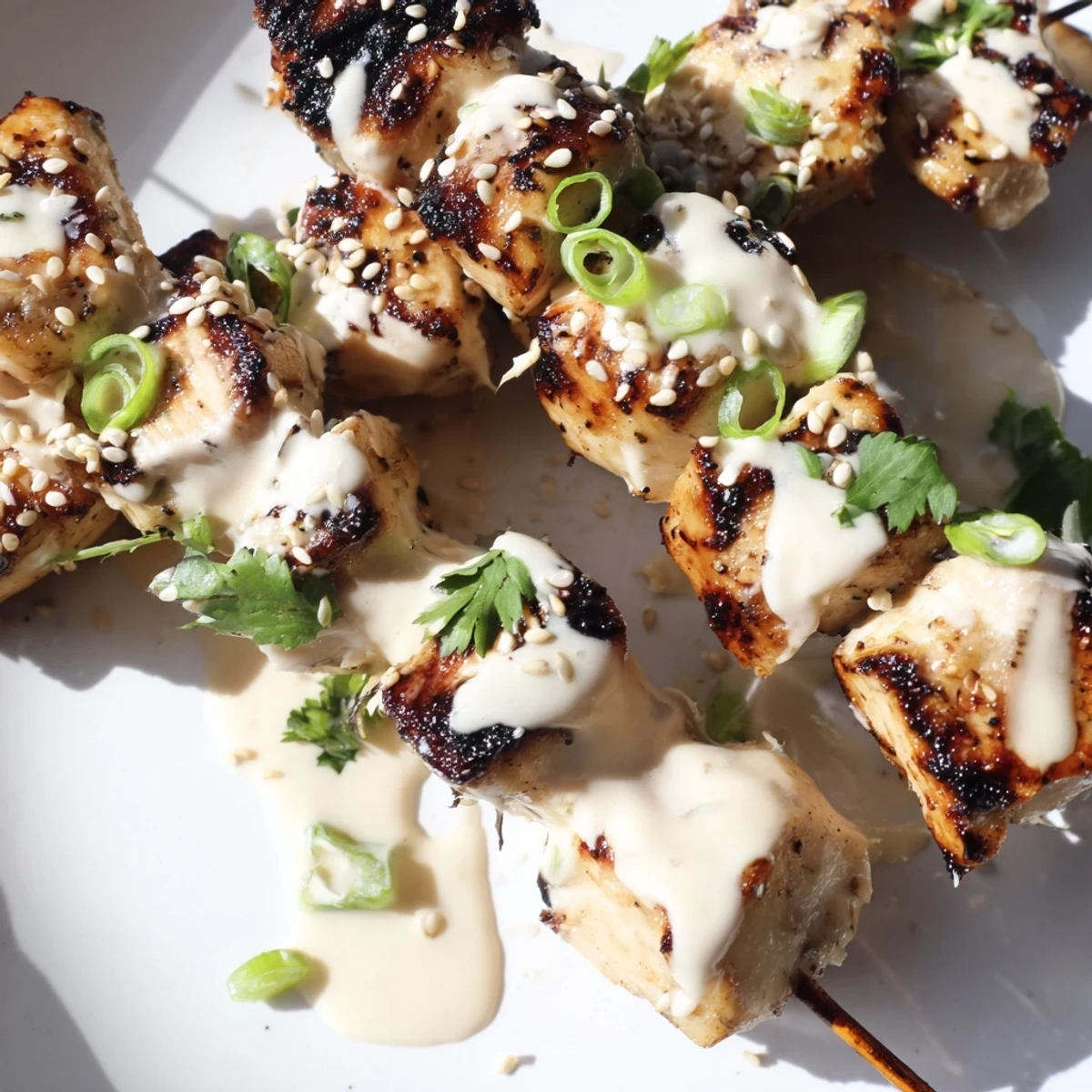 Grilled Bang Bang chicken skewers drizzled with sweet chili mayonnaise and fresh green scallions