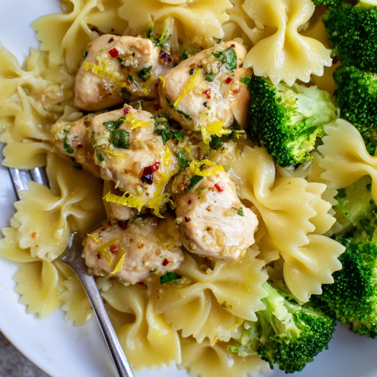 Juicy spiced chicken breasts coated in savory butter alongside crisp broccoli and lemon pasta.
