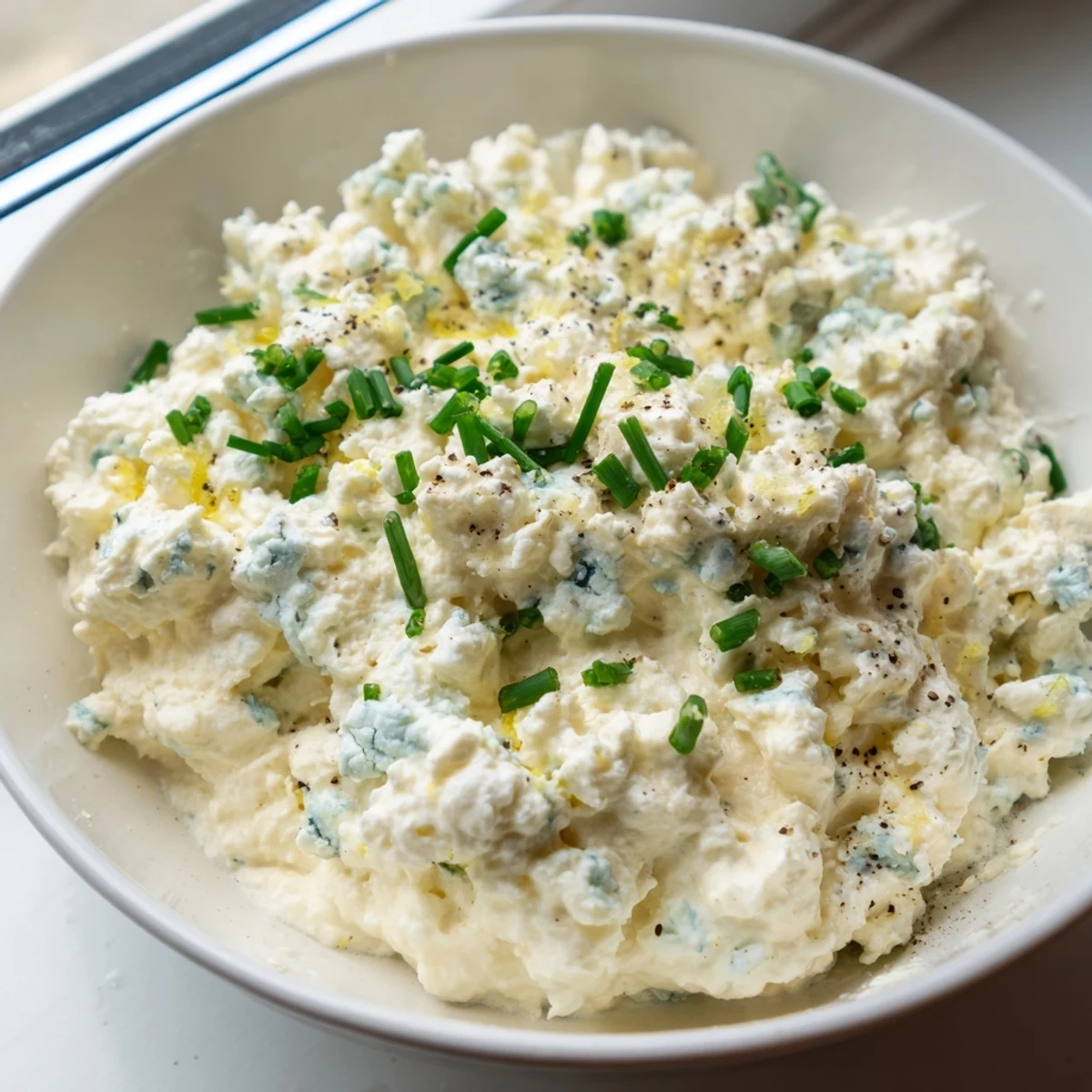 Creamy blue cheese dip in a rustic bowl surrounded by crisp celery and carrot sticks