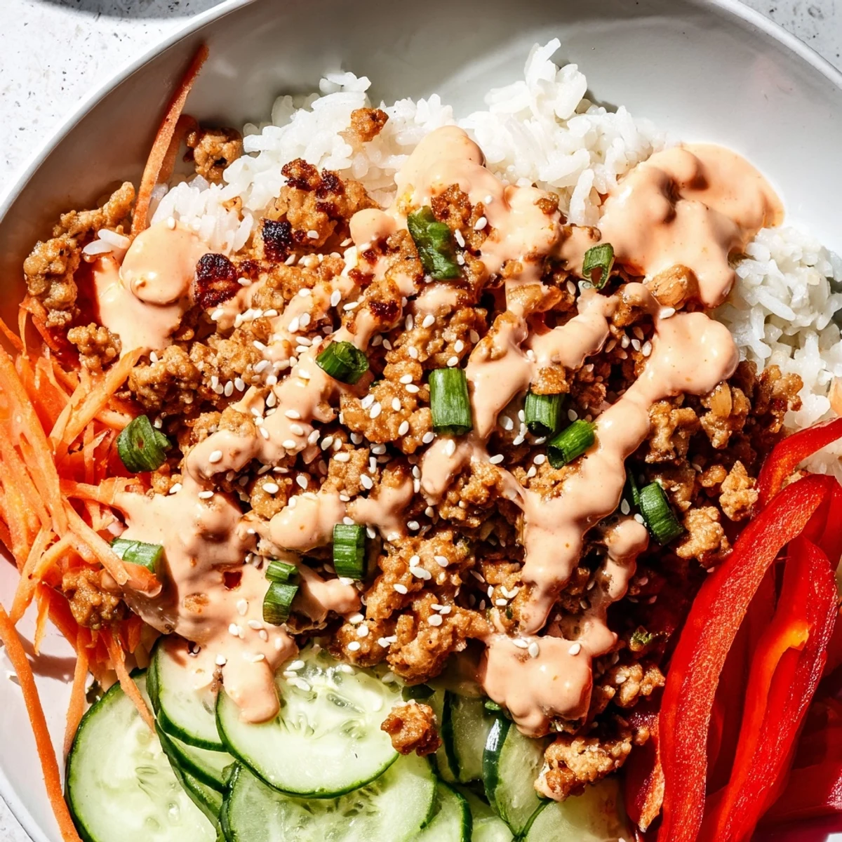 Spicy creamy Bang Bang Sauce coating savory ground turkey served in a fresh rice bowl